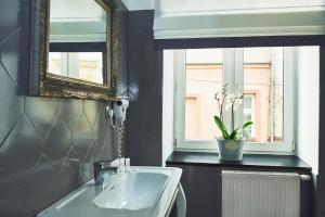 een badkamer met een wastafel, een spiegel en een raam bij Shalom Kazimierz in Krakau +58 foto's