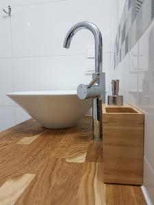 ein Badezimmer mit einem weißen Waschbecken auf einem Holzboden in der Unterkunft Apartament Nowe Maniowy in Maniowy + 21 Fotos