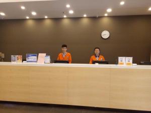 7Days Premium Zhengzhou Jingsan Road Century Lianhua في تشنغتشو: يجلس شخصان في مكتب مع أجهزة اللاپتوپ الخاصة بهم