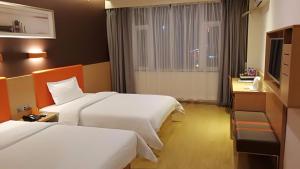 Säng eller sängar i ett rum på 7Days Premium Zhengzhou Jingsan Road Century Lianhua