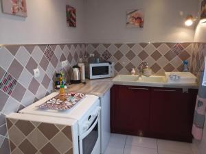 a small kitchen with a stove and a microwave at Comme chez vous in Ruelle-sur-Touvre +4 photos