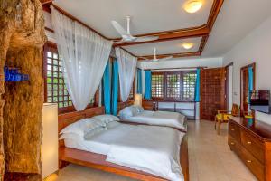 迪亚尼海滩Tequila Sunrise Beach Cabana - Diani Beach的卧室里有两张床和一台电视