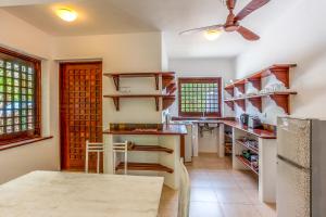 迪亚尼海滩Tequila Sunrise Beach Cabana - Diani Beach的厨房配有木制架子和吊扇