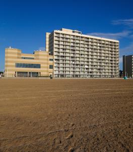 a large building with a field in front of it at Beach Quarters Resort in Virginia Beach