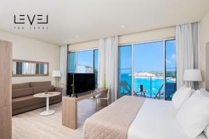 a bedroom with a bed and a couch and a tv at Meliá Cala Galdana in Cala Galdana