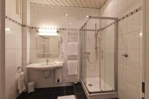a bathroom with a shower and a sink at Hotel Jammerkrug in Gladbeck