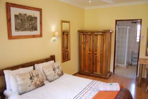 ein Schlafzimmer mit einem Bett und einem Spiegel in der Unterkunft Journey's Inn Africa Guest Lodge in Kempton Park + 66 Fotos