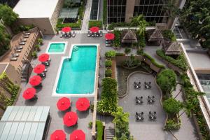 a patio area with a pool, lawn chairs, and umbrellas at Carlton Hotel Singapore (SG Clean) in Singapore