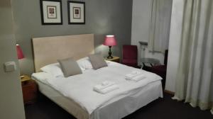una camera da letto con un letto bianco con due asciugamani di Villa Le Matin a Konstancin-Jeziorna