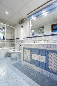 a bathroom with blue cabinets and a large mirror at Casa Viana in Córdoba