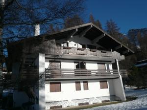 a white building with a balcony on top of it at I mughi - Cortina in Cortina dʼAmpezzo