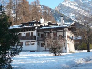 a house in the snow with mountains in the background at I mughi - Cortina in Cortina dʼAmpezzo