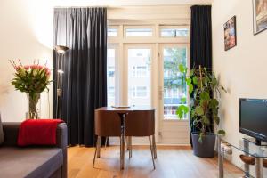 a living room with a table and a window at B&B West City Amsterdam in Amsterdam