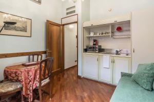 a living room with a table and a kitchen at Hotel Piccola Fenice in Venice