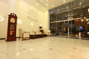 een lobby met een klok en een tafel en stoelen bij The One Hotel in Aurangabad