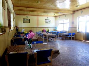 a dining room with tables and blue chairs at Hotel Abu Palace in Leh +27 photos