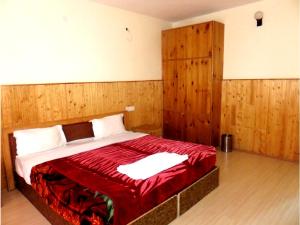 a bedroom with a large bed with wooden walls at Hotel Abu Palace in Leh