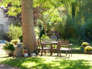 a table and chairs sitting next to a tree at Domaine de Joreau in Gennes