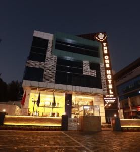 un edificio con un cartel delante de él por la noche en The One Hotel en Aurangabad