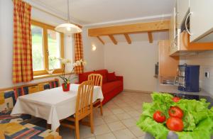 - un salon avec une table et un canapé rouge dans l'établissement Urthalerhof, à Castelrotto