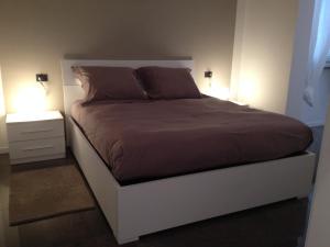 uma cama num quarto com dois candeeiros em Un nido nel centro storico con garage em Aosta