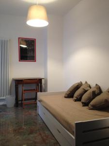 um quarto com uma cama com almofadas e uma mesa em Un nido nel centro storico con garage em Aosta