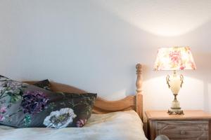 a bedroom with a bed with a lamp on a night stand at Charming and cosy apartment near Lucerne in Römerswil