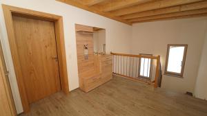 Cette chambre dispose d'une porte en bois et d'un couloir. dans l'établissement Apartment Hanna, à Ramsau im Zillertal
