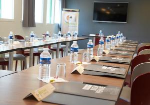 a row of tables with bottles of water on them at Campanile Dijon Congrès Clemenceau in Dijon