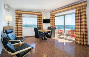 ein Wohnzimmer mit einem Tisch und Stühlen sowie einem Balkon in der Unterkunft Hotel Apartamentos Bajondillo in Torremolinos