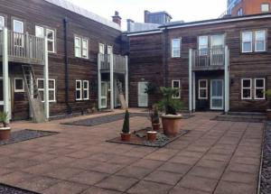 a courtyard with a group of buildings with potted plants at 69D Victoria Street in Sheffield