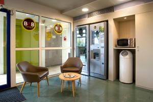 B&B HOTEL Moulins في Toulon-sur-Allier: غرفة انتظار مع كرسيين وطاولة في مبنى