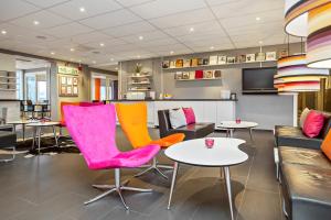a waiting room with bright chairs and tables at Sure Hotel by Best Western Stockholm Alvsjo in Stockholm