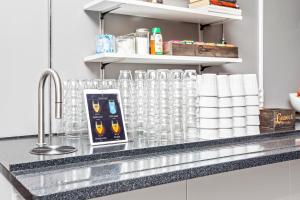 a kitchen counter with glasses and a sink at Sure Hotel by Best Western Stockholm Alvsjo in Stockholm