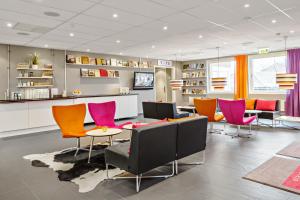 a waiting room with colorful chairs and a table at Sure Hotel by Best Western Stockholm Alvsjo in Stockholm