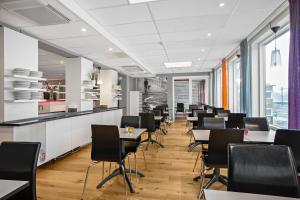 a row of tables and chairs in a restaurant at Sure Hotel by Best Western Stockholm Alvsjo in Stockholm