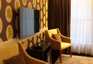 een kamer met 2 stoelen en een televisie aan de muur bij Hotel Esperance in Brussel