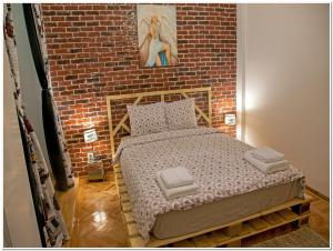 ブカレストにあるSkyview Old Town Apartmentのレンガの壁のドミトリールームのベッド1台分です。