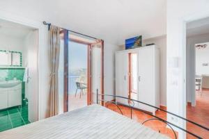 a bedroom with a bed and a bathroom with a balcony at Casa Satriano in Positano