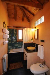 a bathroom with a sink and a tub and a toilet at Casas Rurales Camino del Castaño in Galaroza