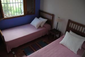 two beds in a room with two windows at Casa Entre Armonías in Zahara de los Atunes