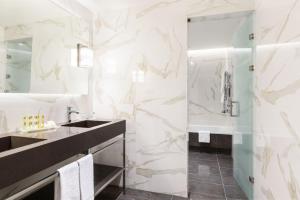 a bathroom with a sink, mirror, and bathtub at Áurea Museum by Eurostars Hotel Company in Lisbon