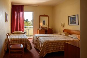 a hotel room with two beds and a window at Congo Palace in Athens