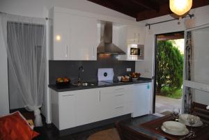a kitchen with white cabinets and a sink at Casa Entre Armonías in Zahara de los Atunes