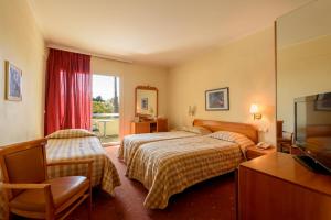 a hotel room with two beds and a television at Congo Palace in Athens