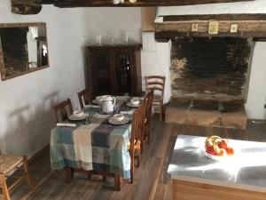 comedor con mesa y sillas y cocina en Cosquer Cottage, en Pluméliau