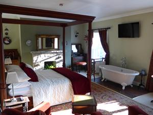 a bedroom with a bed and a bath tub in it at The Mill in Dunfanaghy