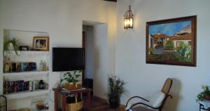 a living room with a flat screen tv and a chair at La Casa de Mis Padres in El Pinar del Hierro