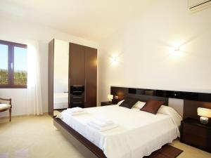 カンパネにあるBelvilla by OYO Can Melisのベッドルーム(大きな白いベッド1台、椅子付)