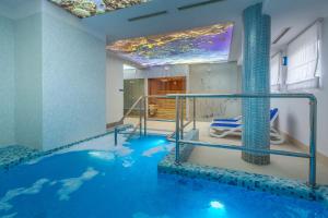 a indoor swimming pool with blue water in a room at Pensjonat Luan in Władysławowo
